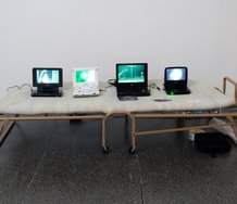 Campbell Patterson, Orewa 1-4, 2010, digital video transferred to DVD, 4 portable DVD players, single bed, carry bag, drink bottle, plastic bag, variable dimensions