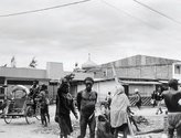 Photograph on page 106. 'Dani tribesman walks through Wamena town with mosque in background, highlands of West Papua/Indonesia 1995.'
