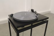 Sarah Callesen: Side A: Untitled Drawing, 20 mins at 33rpm; Side B: Troubleshooting 1, 20 mins at 33 rpm. 12 " polycarbonate disc, record player, speakers , cables, metal and glass stand. Photo: Cameron Town